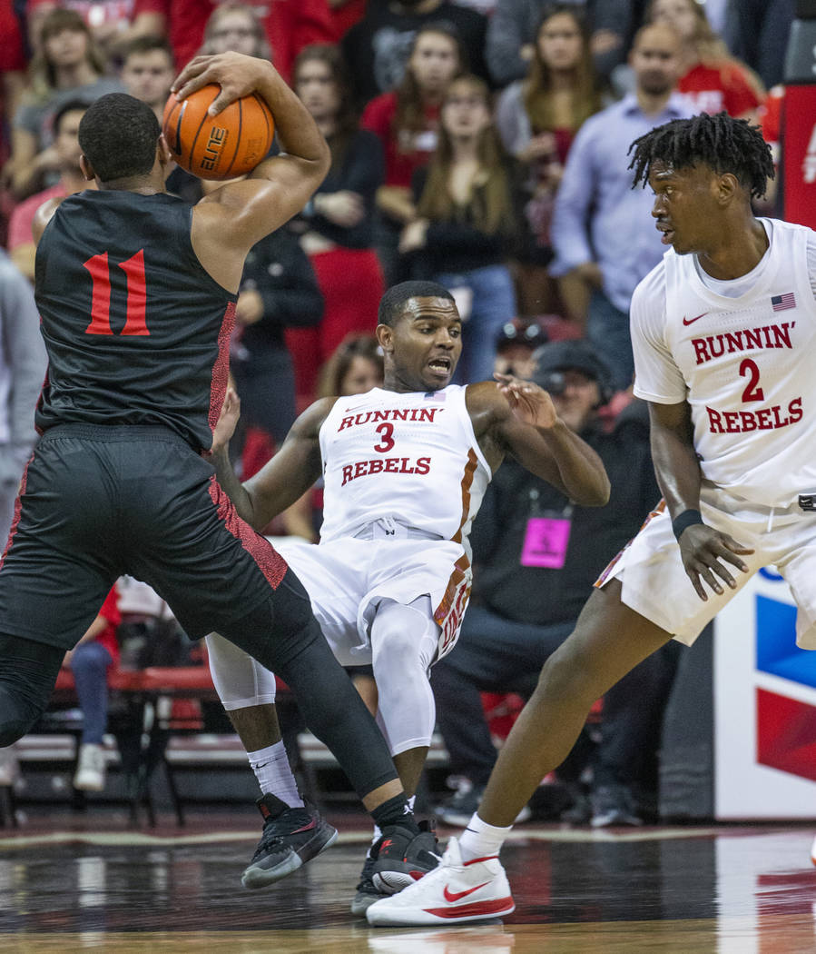 San Diego State Aztecs forward Matt Mitchell (11, left) charges into UNLV Rebels guard Amauri H ...