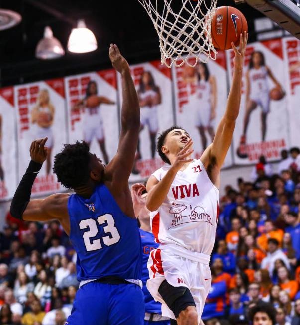 Coronado's Max Howard (21) goes to the basket past Bishop Gorman's Mwani Wilkinson (23) during ...