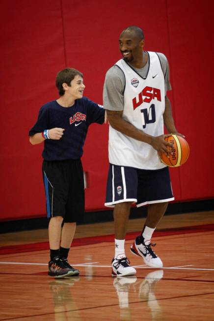 2012 USA Basketball Men's National Team player Kobe Bryan, right, shoots with a young man durin ...