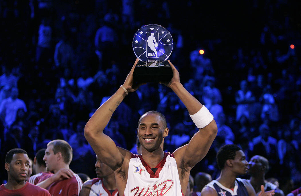 NBA Western Conference player Kobe Bryant holds up the Most Valuable Player trophy after it was ...