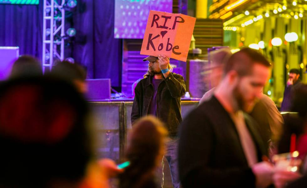 Aaron Young holds up a sign at the Fremont Street Experience as a memorial to Kobe Bryant follo ...