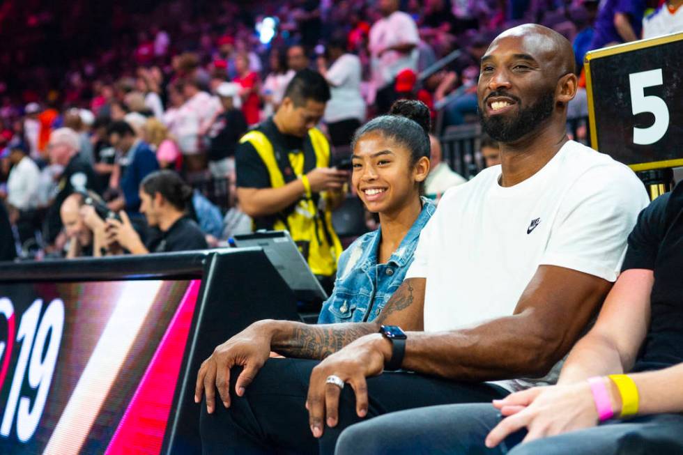 NBA legend Kobe Bryant sits with his daughter, Gianna, during the first half of the WNBA All-St ...