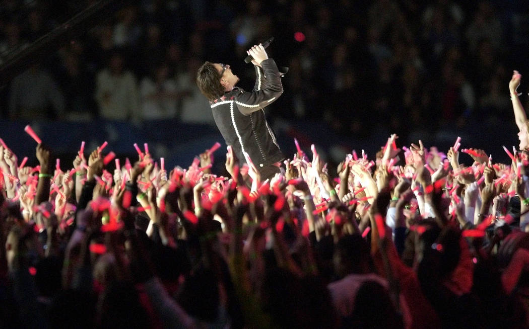 Bono performs amidst a sea of candles at halftime of Super Bowl XXXVI Sunday, Feb. 3, 2002 in N ...