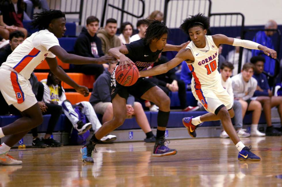 Durango guard Keshon Gilbert (10) moves the ball between Bishop Gorman guards Will McClendon (1 ...