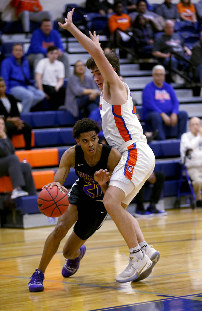 Durango guard Anthony Hunter (21) drives around Bishop Gorman forward Braden Lamar (13) in the ...