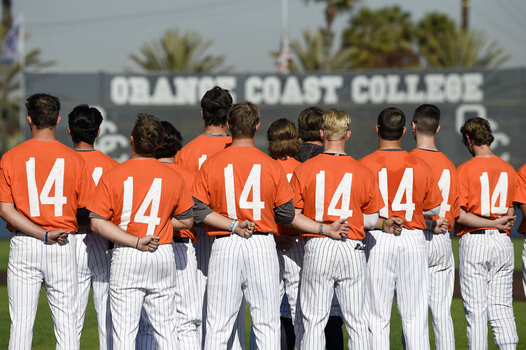 The Orange Coast College baseball players stands for the national anthem while wearing shirts w ...