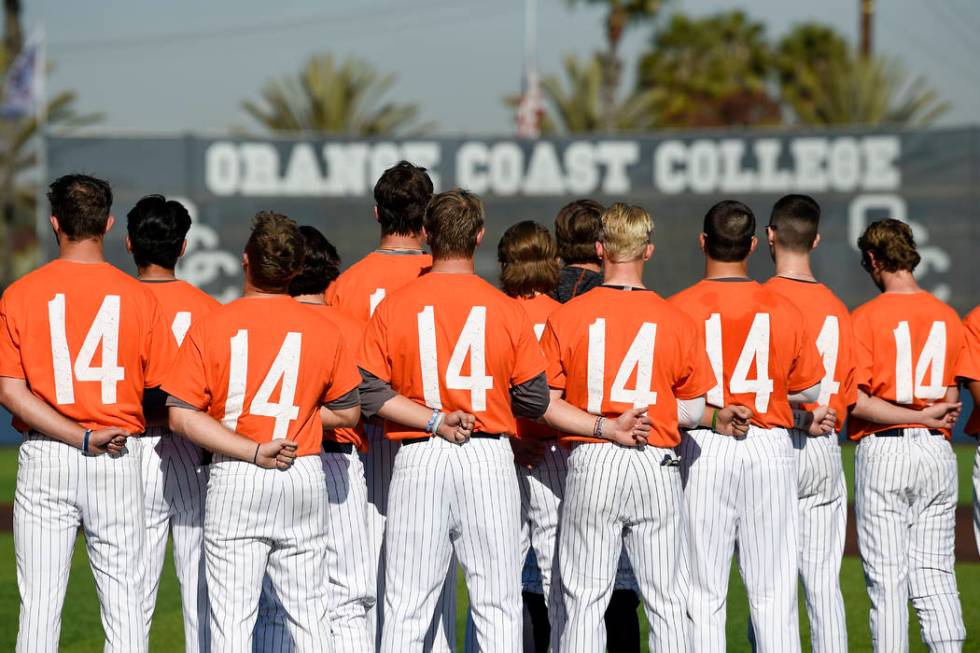 The Orange Coast College baseball players stands for the national anthem while wearing shirts w ...