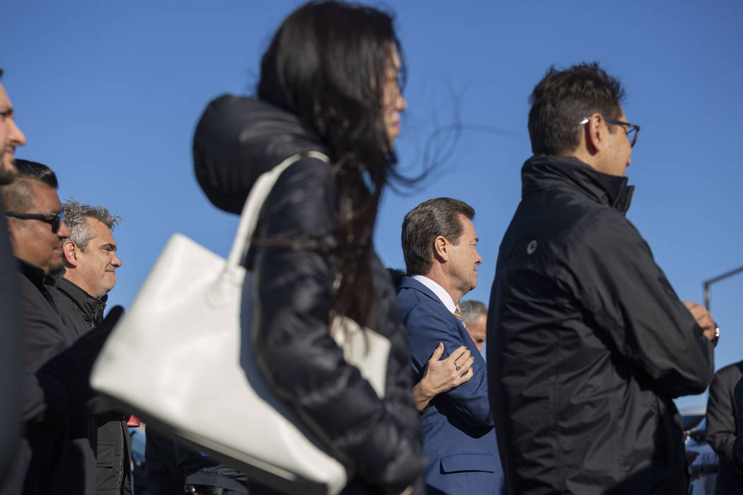 Wind blows as community members listen to speeches during the official opening ceremony for the ...