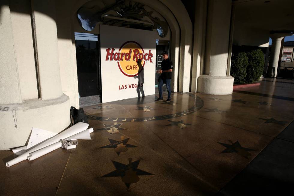 Carlos Villa of Warrior Wraps installs a a wall graphic at the Hard Rock Cafe in Las Vegas ahea ...