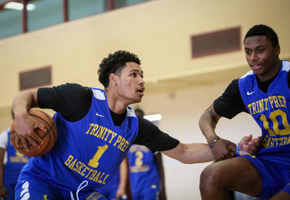 Trinity International junior Daishen Nix defends the ball from teammate Marlon Lestin during a ...