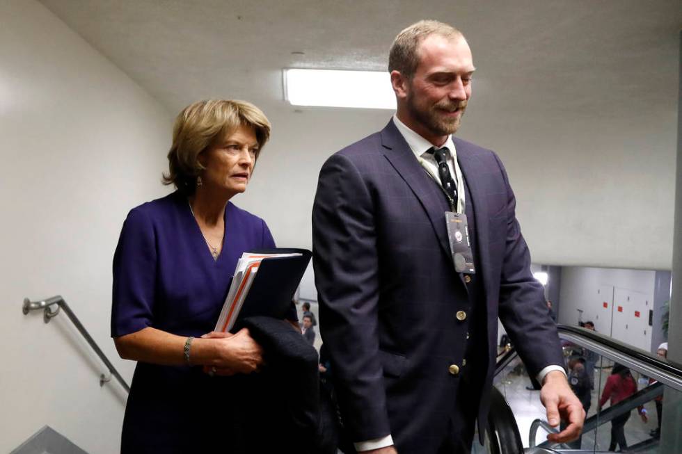 Sen. Lisa Murkowski, R-Alaska, left, arrives on Capitol Hill in Washington, Thursday, Jan. 30, ...