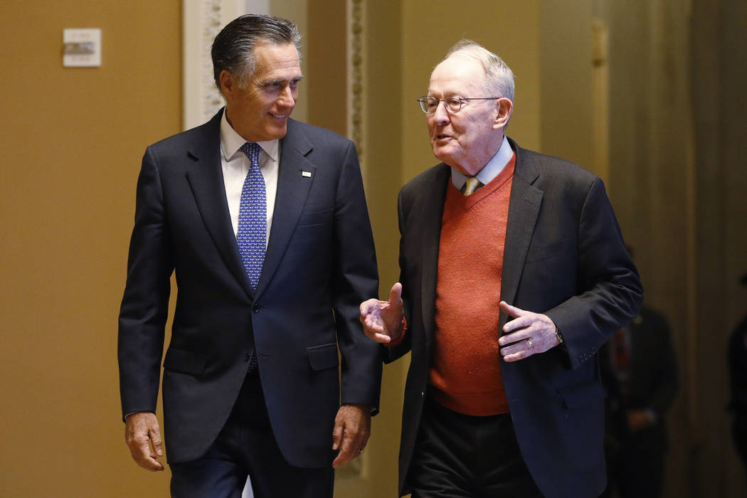 Sen. Mitt Romney, R-Utah, left, and Sen.m Lamar Alexander, R-Tenn., return to the Senate chambe ...