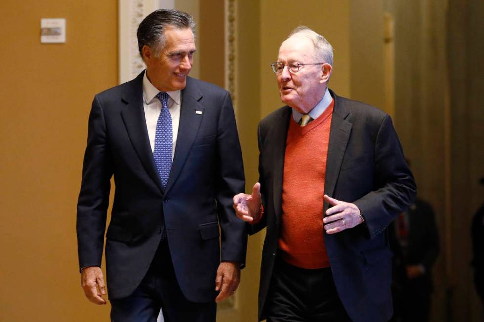 Sen. Mitt Romney, R-Utah, left, and Sen.m Lamar Alexander, R-Tenn., return to the Senate chambe ...