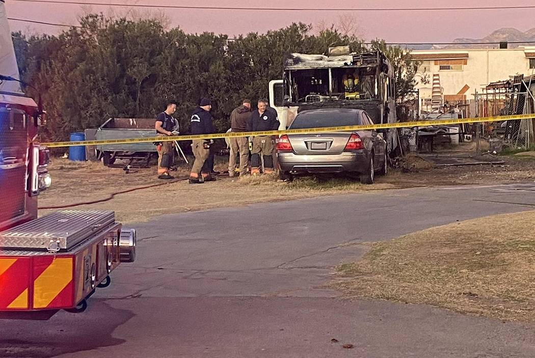 Las Vegas fire investigators at the scene of a fatal fire in a recreational vehicle parked next ...