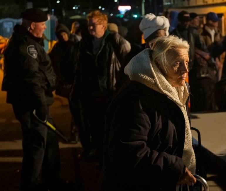 People wait in line to check in and get a sleeping mat at the Courtyard Homeless Resource Cente ...