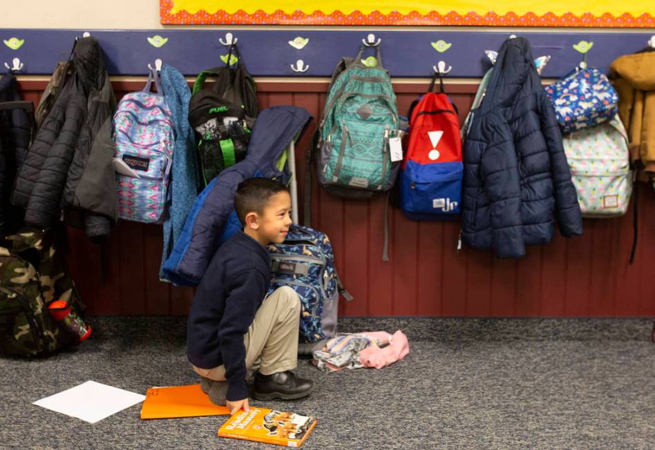 Aiden Hix retrieves books from his backpack before reading group at American Preparatory Academ ...