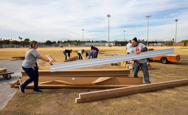 Employee volunteers from Health Plan of Nevada work to build new bleachers and goals for the so ...