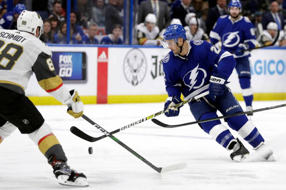 Tampa Bay Lightning defenseman Kevin Shattenkirk (22) tries to control a bouncing puck in front ...