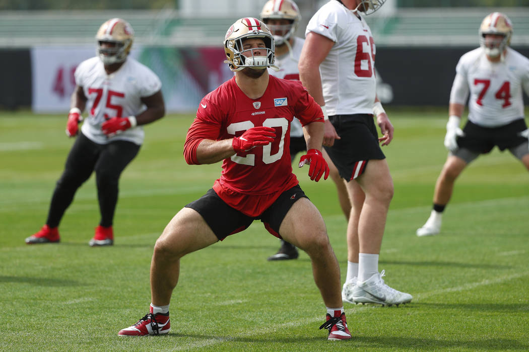 San Francisco 49ers Nick Bosa, foreground, warms up during practice for the NFL Super Bowl 54 f ...