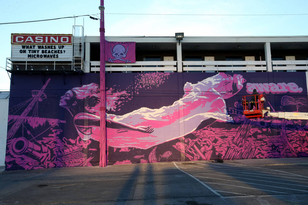 Unidentified crew members paint the mural "Mermaids Don't Wear Skirts," a collaborati ...