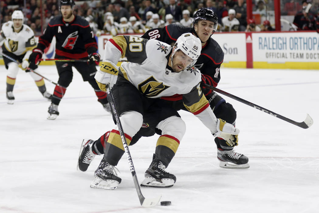 Vegas Golden Knights center Chandler Stephenson (20) controls the puck next to Carolina Hurrica ...