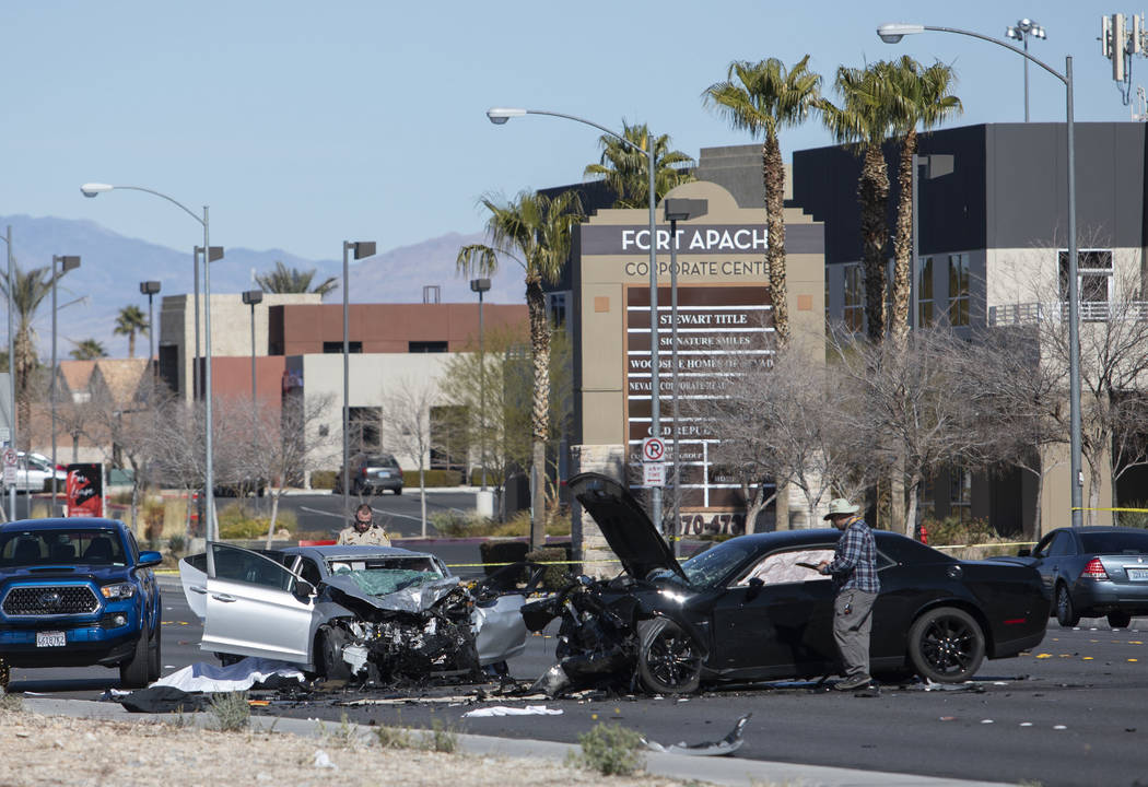 Investigators work at the scene of a fatal collision at the intersection of South Fort Apache ...