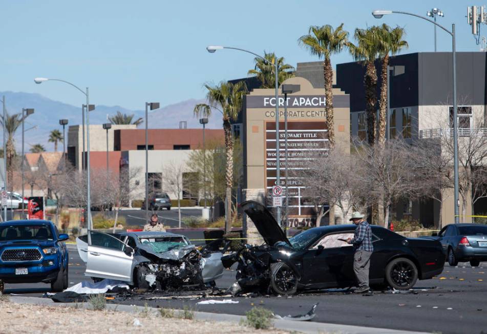 Investigators work at the scene of a fatal collision at the intersection of South Fort Apache ...