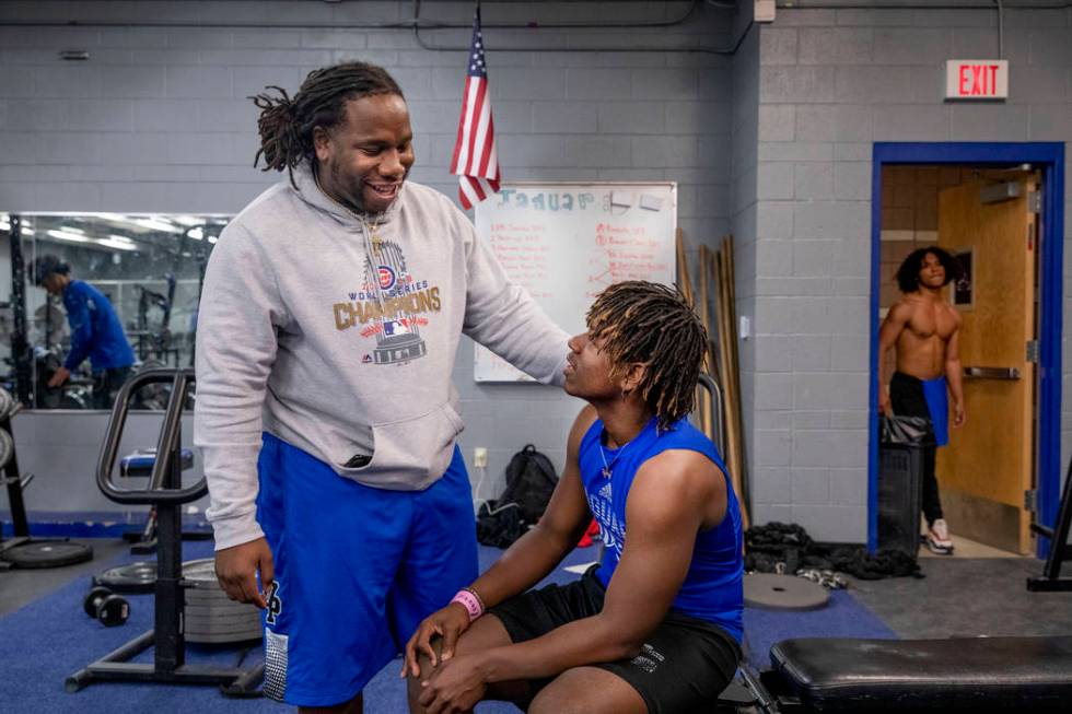 Desert Pines High School assistant football coach David Hill, left, speaks with junior running ...