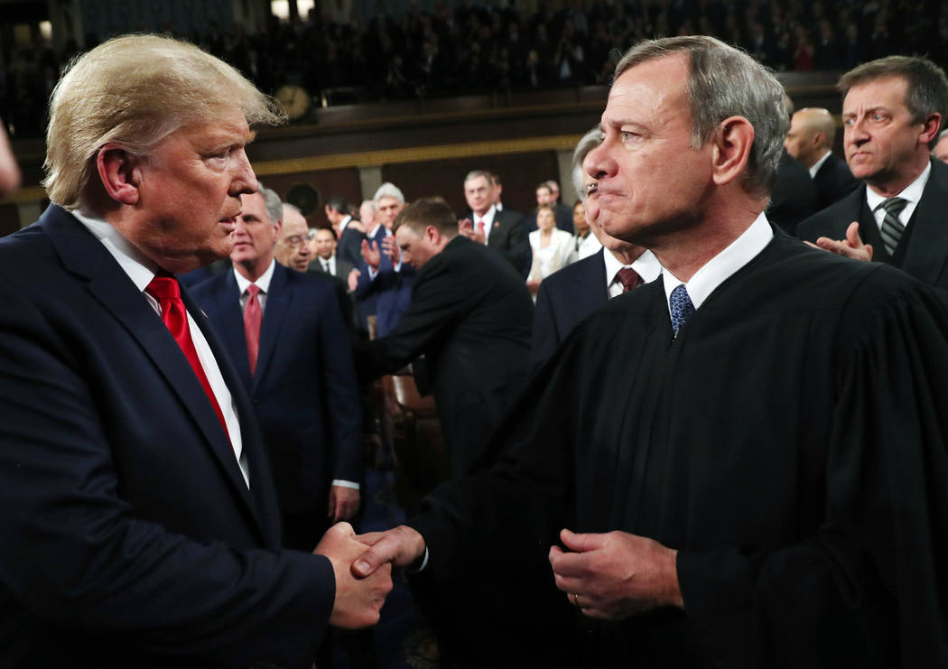 President Donald Trump greets Supreme Court Chief Justice John Roberts as he arrives to deliver ...