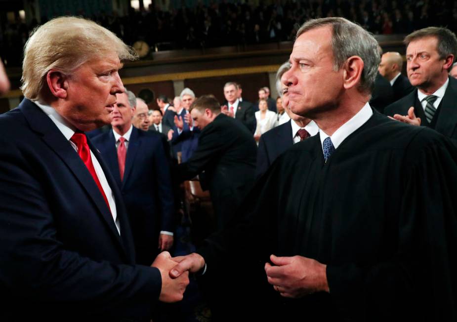 President Donald Trump greets Supreme Court Chief Justice John Roberts as he arrives to deliver ...