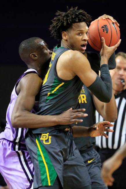 Baylor forward Freddie Gillespie, right, is covered by Kansas State forward Makol Mawien, left, ...