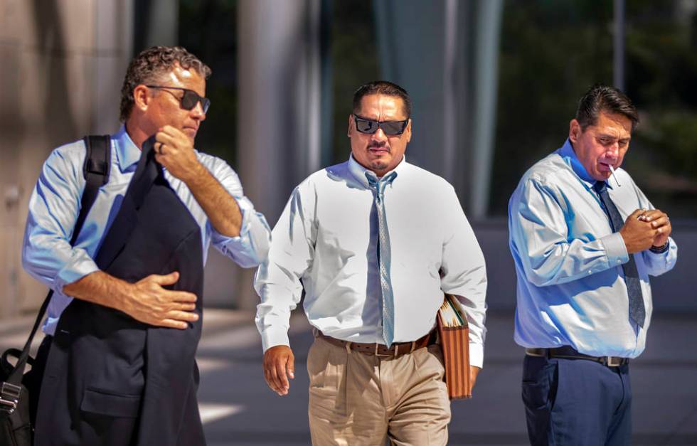 Counselor Mark Fleming, left, walks out with defendant Albert Lopez past defendant Bradley Camp ...