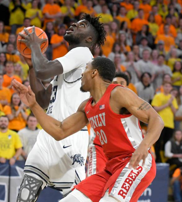 UNLV guard Bryce Hamilton (13) shoots as Utah State forward Justin Bean (34) defends during the ...