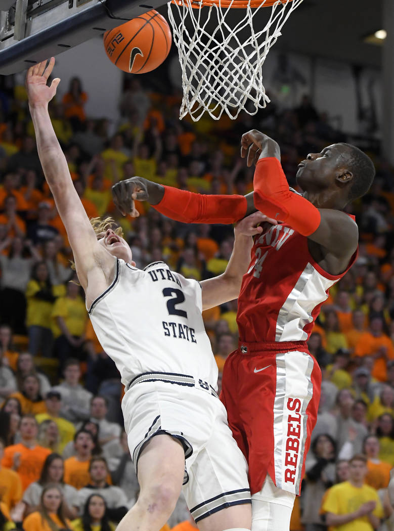 Utah State guard Sam Merrill, left, and forward Justin Bean force a jump ball against UNLV guar ...