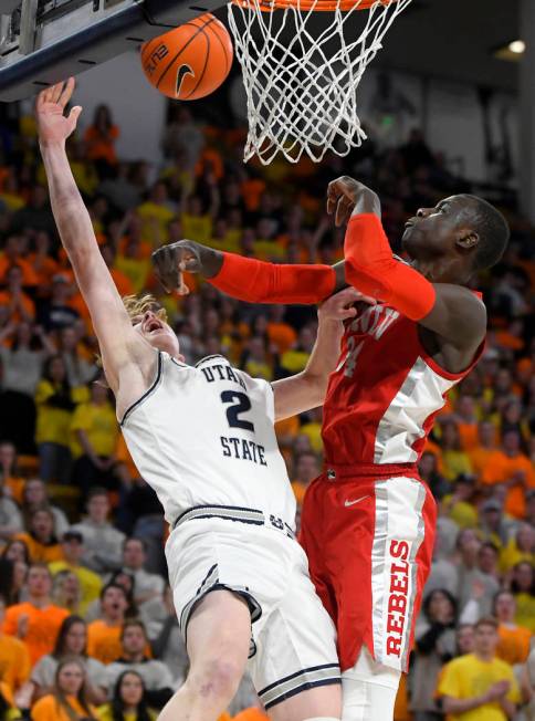 Utah State guard Sam Merrill, left, and forward Justin Bean force a jump ball against UNLV guar ...