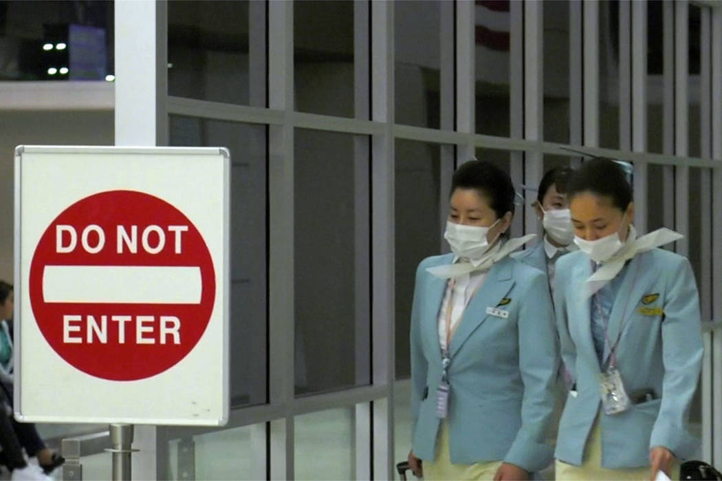 Korean Air workers leave Flight 005 after landing at McCarran International Airport in Las Vega ...