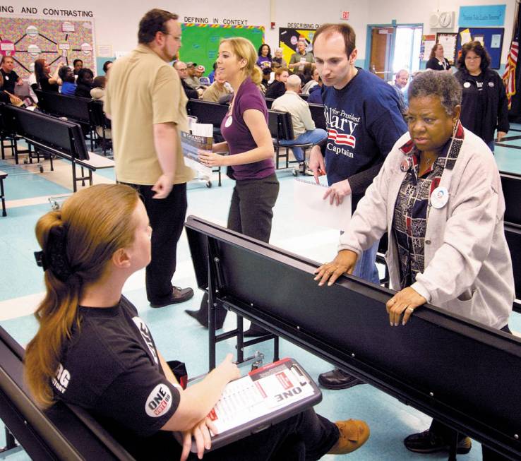 Tricia Miller, left, listens as Obama volunteer Joyce Burton and Clinton precinct captain Noah ...