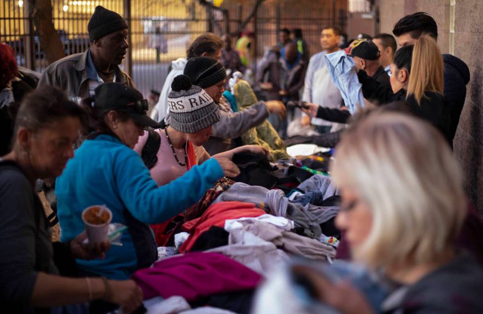 Homeless individuals sift through donated clothing after eating dinner at the Las Vegas Rescue ...