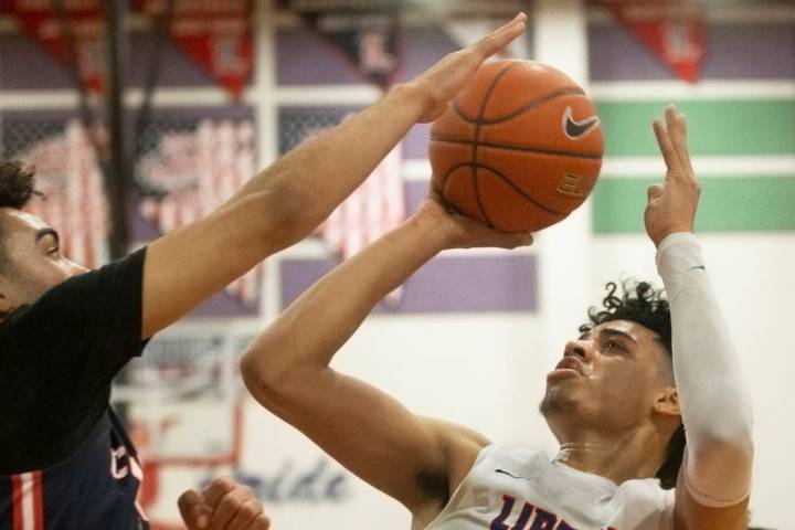 Liberty senior guard Julian Strawther (0) shoots over Coronado senior guard Dallas Rider (3) in ...