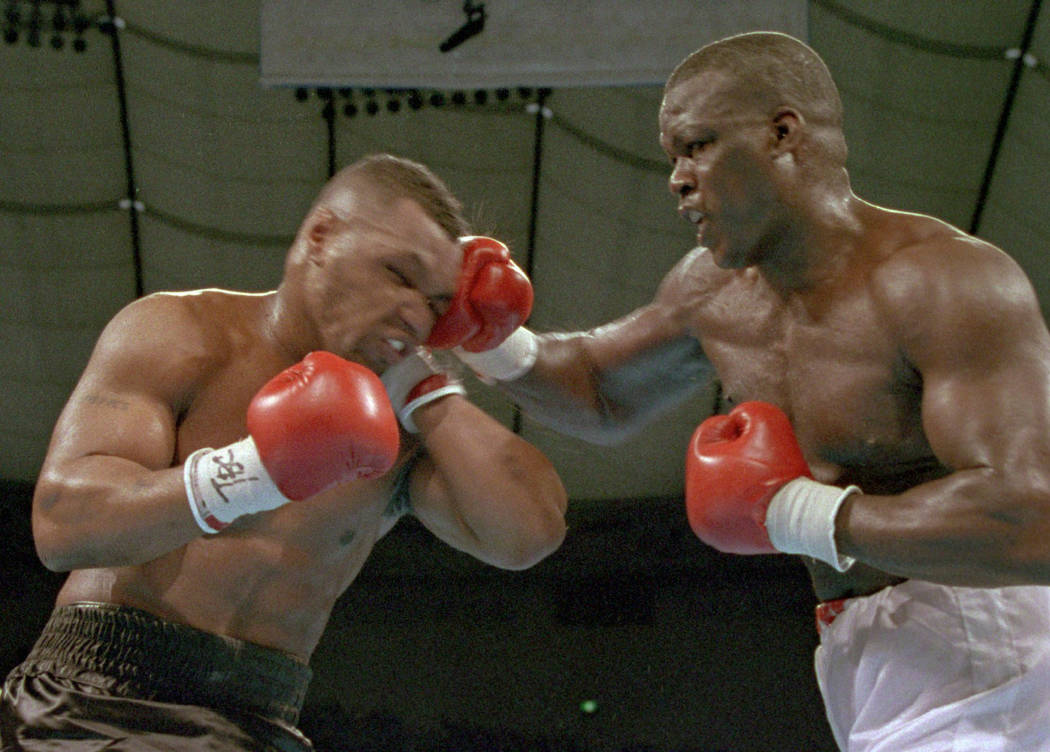 James "Buster" Douglas, right, hits Mike Tyson with a hard right in the face during t ...