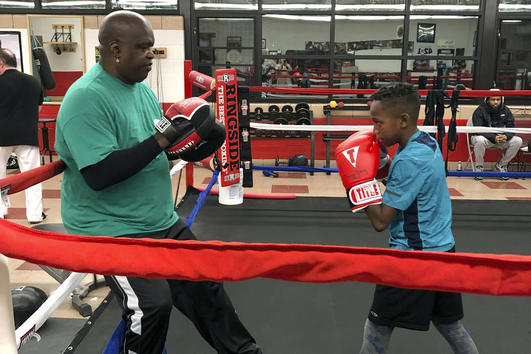 James "Buster" Douglas, the former world heavyweight champion, works with a student at the Thom ...