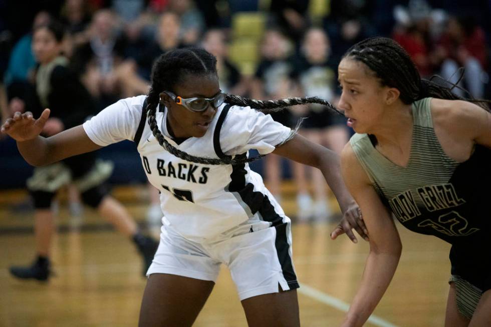 Desert Oasis's forward Jordyn Stroud (12) guards Spring Valley's guard Garrisen Freeman (32) on ...