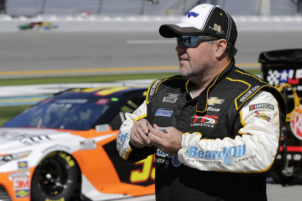 Brendan Gaughan walks along pit road during NASCAR auto race qualifying at Daytona Internationa ...