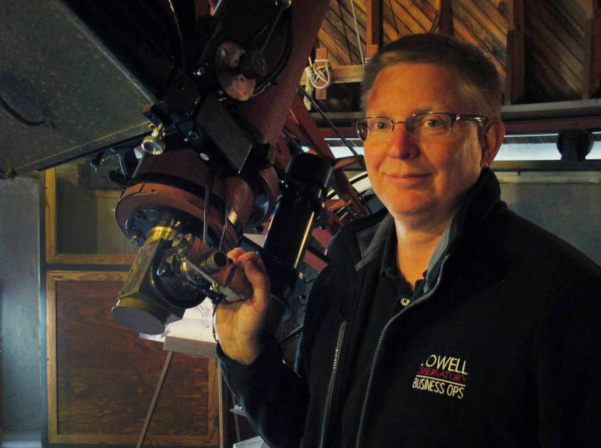 Kevin Schindler of Lowell Observatory stands next to the Pluto telescope in Flagstaff, Ariz., i ...