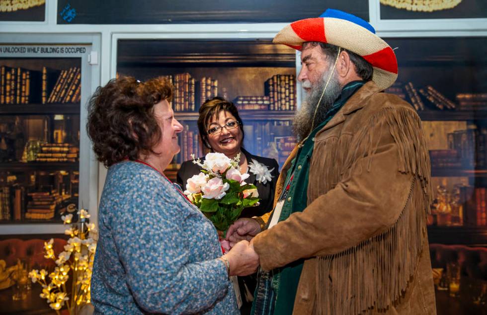 The Rev. Diana Moran, center, conducts a wedding renewal ceremony for Rose Mallory, left, and h ...