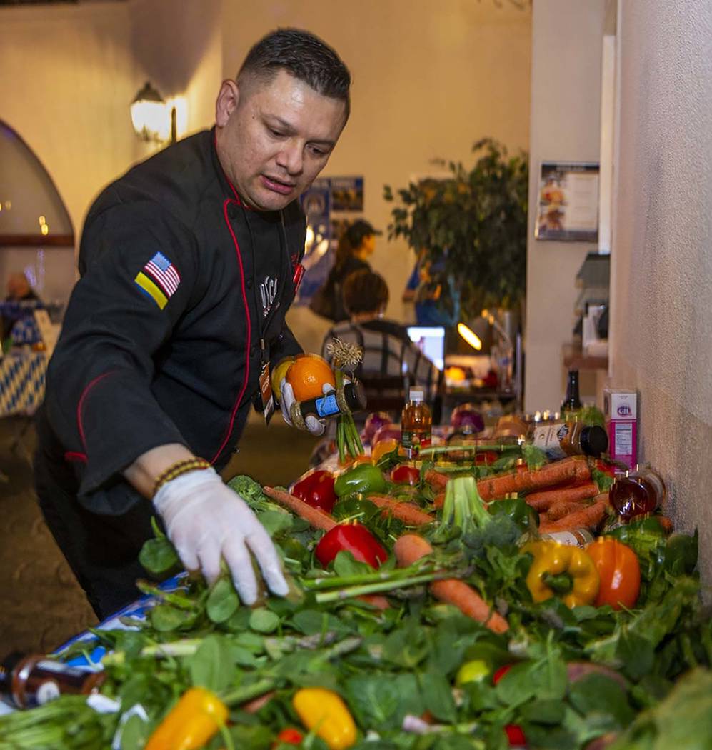 Chef Oscar Sanchez, Chef Battle Las Vegas winner, grabs more vegetables from the pantry as time ...