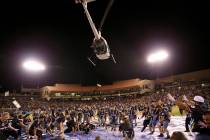 Fans rush to collect a piece of the $5,000 dropped from a helicopter at half time during an USL ...