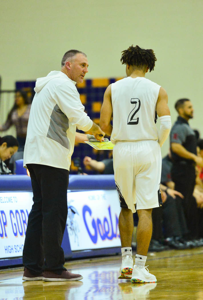 Faith Lutheran head coach Bret Walter talks to Donavan Jackson (2) during a game between Libert ...