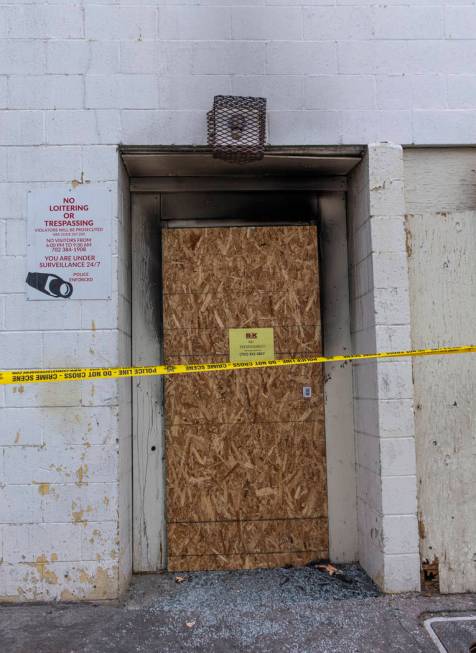 The broken rear glass exit door of the Alpine Apartment Motel is boarded up the day after the D ...