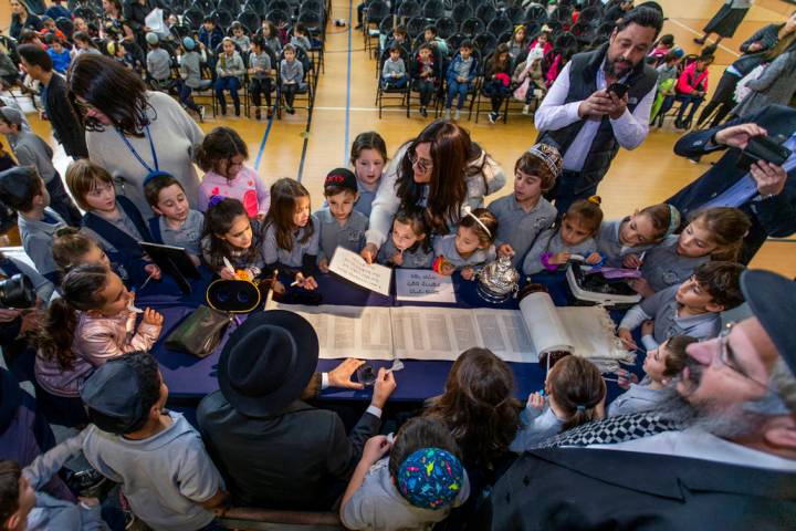 Rabbi Dovid Bressman, bottom left, as Sofer readies to inscribe the new Torah surrounded by fir ...